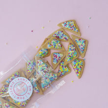 Load image into Gallery viewer, Triangular dog treats with multicolored sprinkles on top, packaged in a clear plastic bag with a label.